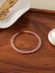 Close-up of pink crystal tennis bracelet in gold finish with a secure folding clasp