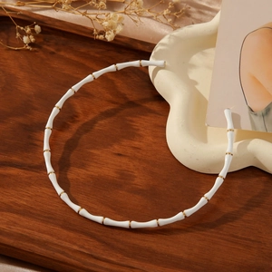 Minimalist white bamboo joint choker with gold stainless steel accents for women