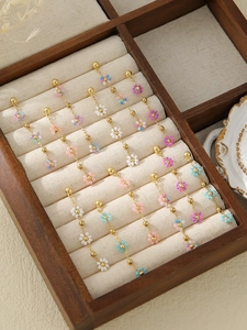 Detail of beaded floral tassel earrings with gold-plated chains in a jewelry box