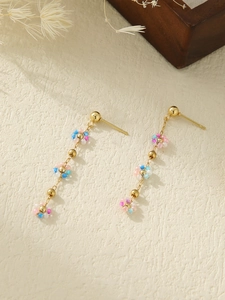 Detail of beaded daisy earrings with pink and blue floral clusters in golden setting