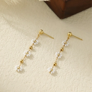 Elegant gold drop earrings with white daisy flower petals and long metallic tassels