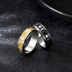 Detailed view of rotating stress relief rings with gold and black celestial motifs