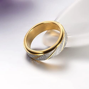 Detail van gouden titanium ring met gezandstraalde zilveren streep en draaistructuur