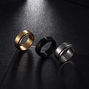 Trío detallado de anillos giratorios de acero de titanio cepillado mate en oro, negro y plata