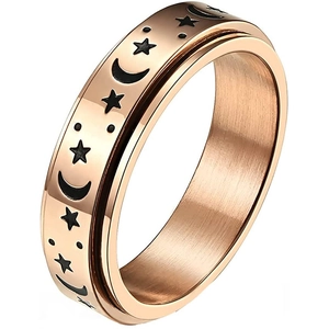 Vista detallada de un anillo giratorio de oro rosa con símbolos de estrellas y lunas grabados