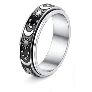 Macro shot of silver rotating ring featuring black enamel sun moon and star motifs
