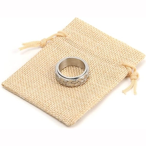 Detailed view of silver rotatable ring with leaf patterns and burlap storage pouch