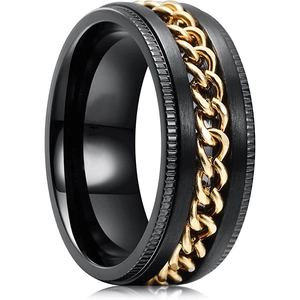Détail d'une bague rotative noir et or avec chaîne tournante et finition brossée mate