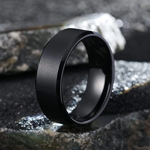 Macro-opname van geborsteld matzwart titanium ring met gepolijste randen op donkere steen
