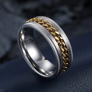 Détail macro de la chaîne dorée rotative sur une bague anti-stress en acier brossé
