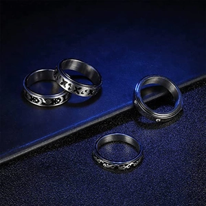 Detalle de cuatro anillos giratorios de acero inoxidable con motivos de luna y mariposa