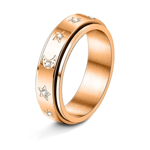 Detailed close-up of rose gold spinner ring featuring star and moon motifs and crystals