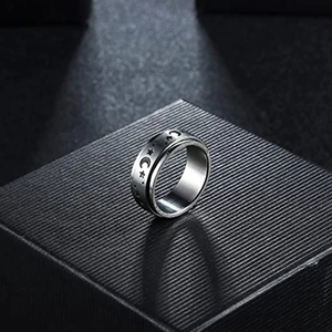 Detail of rotating celestial star and moon pattern on silver titanium steel ring