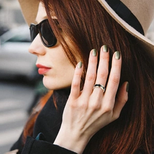 Primer plano de un elegante anillo termosensible en negro y dorado usado por un modelo