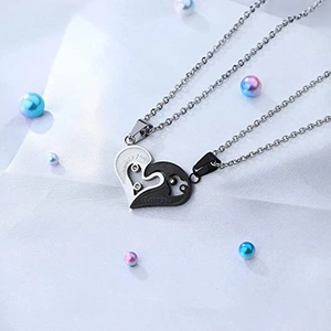 Macro detail of couple's puzzle heart necklaces with I Love You engraving and white crystal