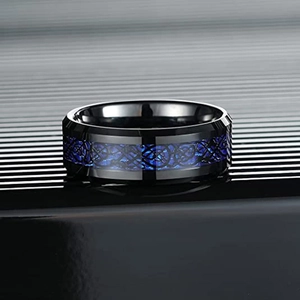 Nahaufnahme eines polierten schwarzen Titanstahlrings mit blauem keltischen Drachenmuster