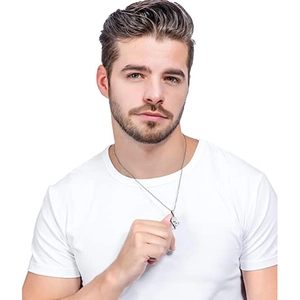 Close-up of a silver heart pendant necklace for men worn over a white casual t-shirt
