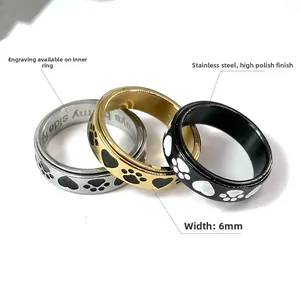 Close-up of three spinner rings with paw prints and custom inner band engraving