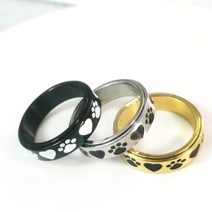 Close-up of rotating heart and paw print rings in gold, silver, and black finish