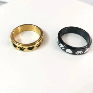 Detail view of gold and black spinning rings with paw prints and heart patterns