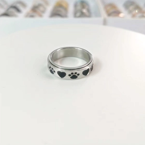 Detailed close-up of silver rotating ring with black enamel hearts and paw prints
