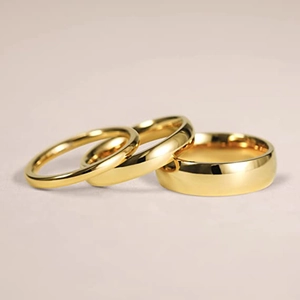 Detailopname van drie gepolijste titanium stalen ringen met gladde gouden afwerking