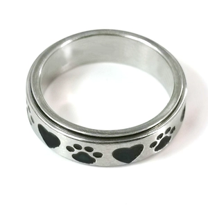 Close-up of rotatable stainless steel ring with black heart and paw print engravings