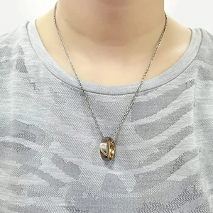 Detail of interlocking silver and gold ring necklace featuring heart design and crystals