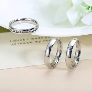Detailed close-up of silver steel rings with crystal paving and polished smooth finish