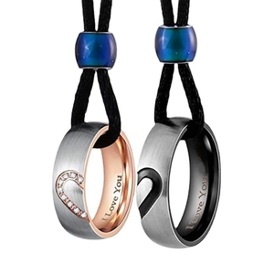 Detail of coupled heart rings with I Love You engraving on black braided cords