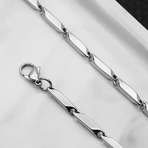 Detailed close-up of polished silver cylinder chain links and secure lobster clasp closure