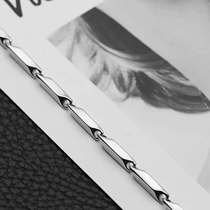 Detail of silver polished stainless steel necklace with bamboo cylinder chain links
