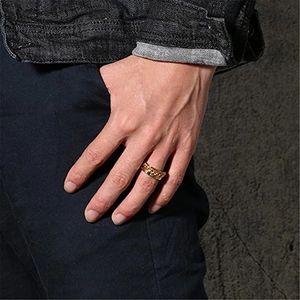 Detail of a rotating gold titanium steel ring with a central Roman chain relief texture