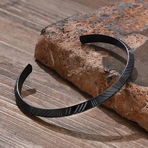 Vista detallada del brazalete de acero inoxidable negro mate con texturas diagonales
