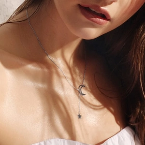 Collar de acero inoxidable con colgante de luna y estrella en modelo con sombras suaves