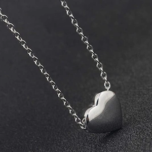 Foto macro del colgante de corazón de plata pulida con una cadena de eslabones fina
