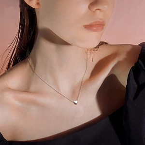 Collar con colgante de corazón pulido en acero de titanio sobre una modelo