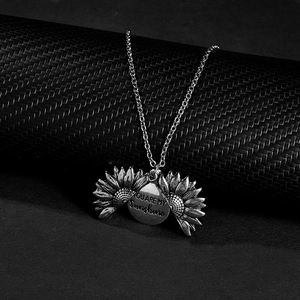 Vue détaillée du pendentif tournesol ouvrant avec gravure You Are My Sunshine en argent