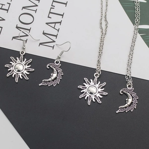 Detailed set of vintage silver sun and moon pendant necklaces and earrings on display