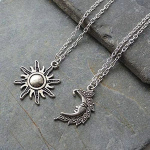 Retro sun and moon pendant necklaces in silver finish on a natural stone background