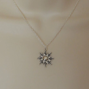 Detailed macro view of retro sun pendant featuring antique silver finish and sunburst pattern