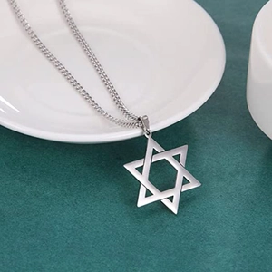 Collana con pendente a stella a sei punte in acciaio argento lucido su piatto bianco