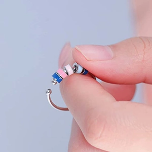 Detalle de cuentas de colores giratorias en un anillo antiestrés de acero inox