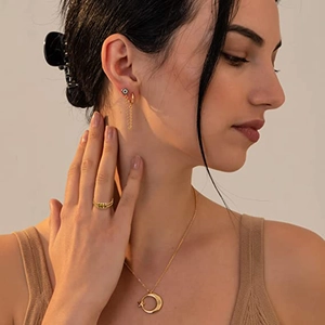 Detailopname van model met maan-ster ketting en dubbele ring met groene kralen