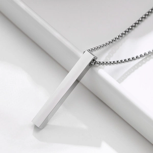 Vista macro del colgante rectangular de plata pulida con cadena de perlas de estilo minimal