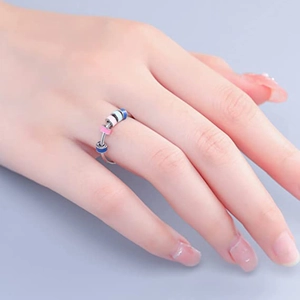 Primer plano de cuentas de esmalte de colores que rotan en un anillo de ansiedad