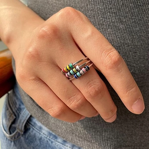 Juego de tres anillos giratorios con cuentas de esmalte de colores en banda de acero plata