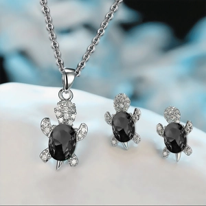 Macro shot of silver turtle jewelry set with black onyx and sparkling zircon crystals