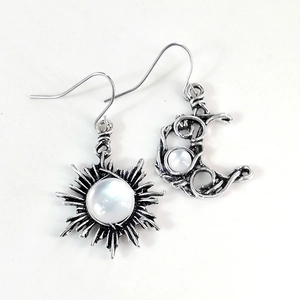 Détail des boucles d'oreilles soleil et lune avec pierre de lune et fini argent antique