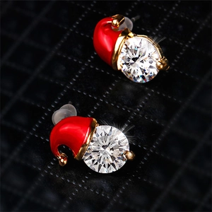 Macro view of Christmas snowman hat earrings with red enamel and sparkling zircons